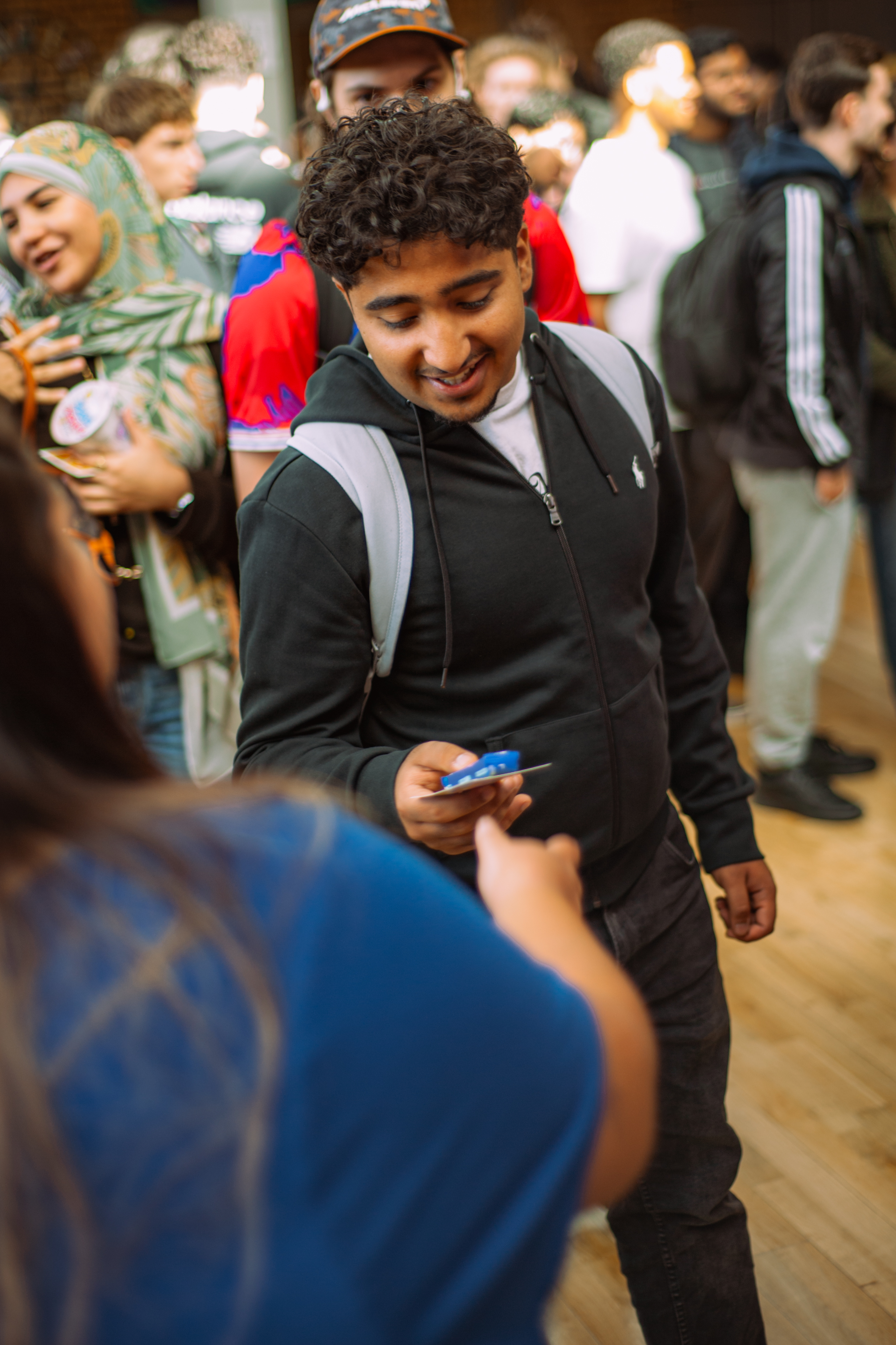 Over the should shot of handing an information card to another person.