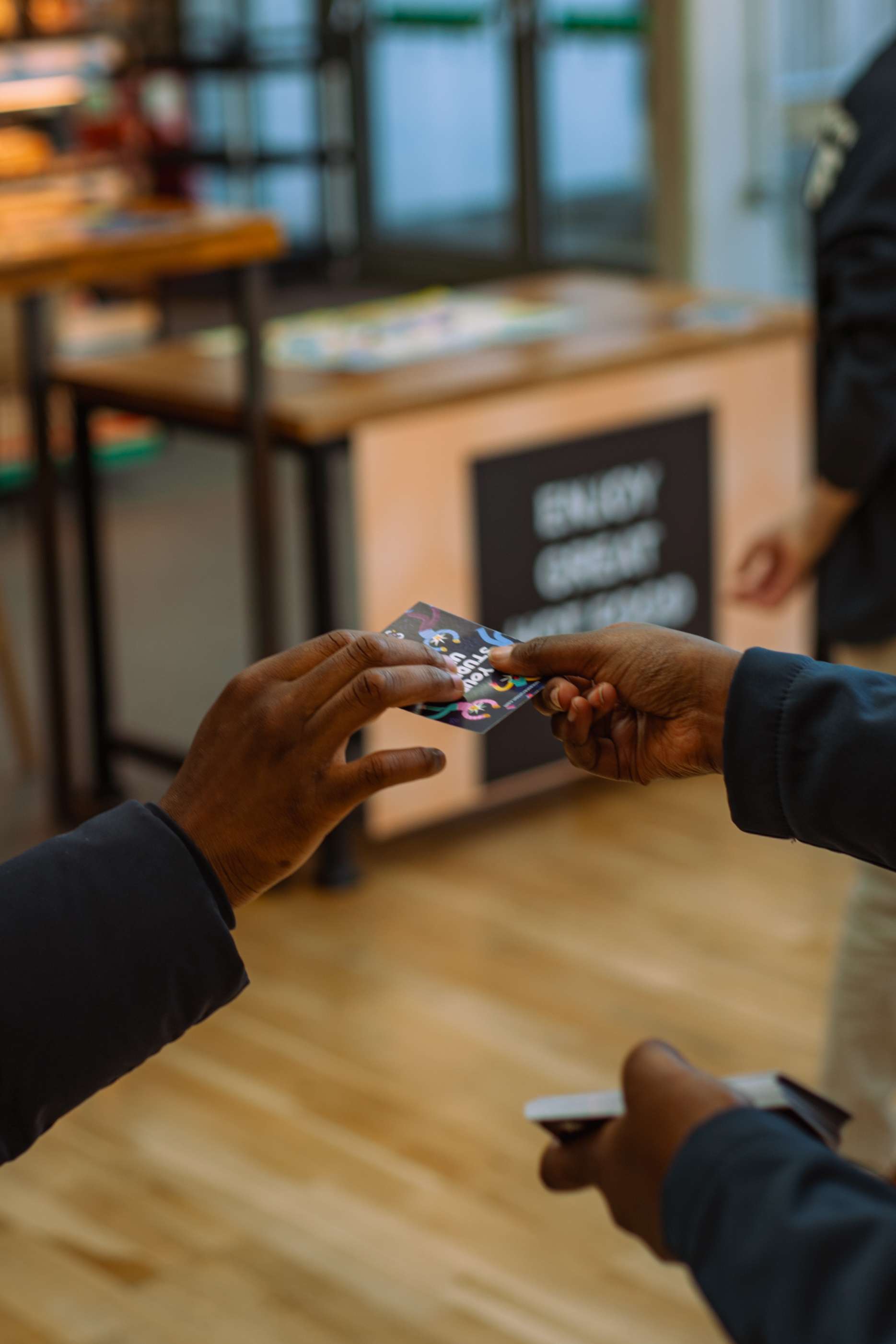Two hands exchanging a cards with information