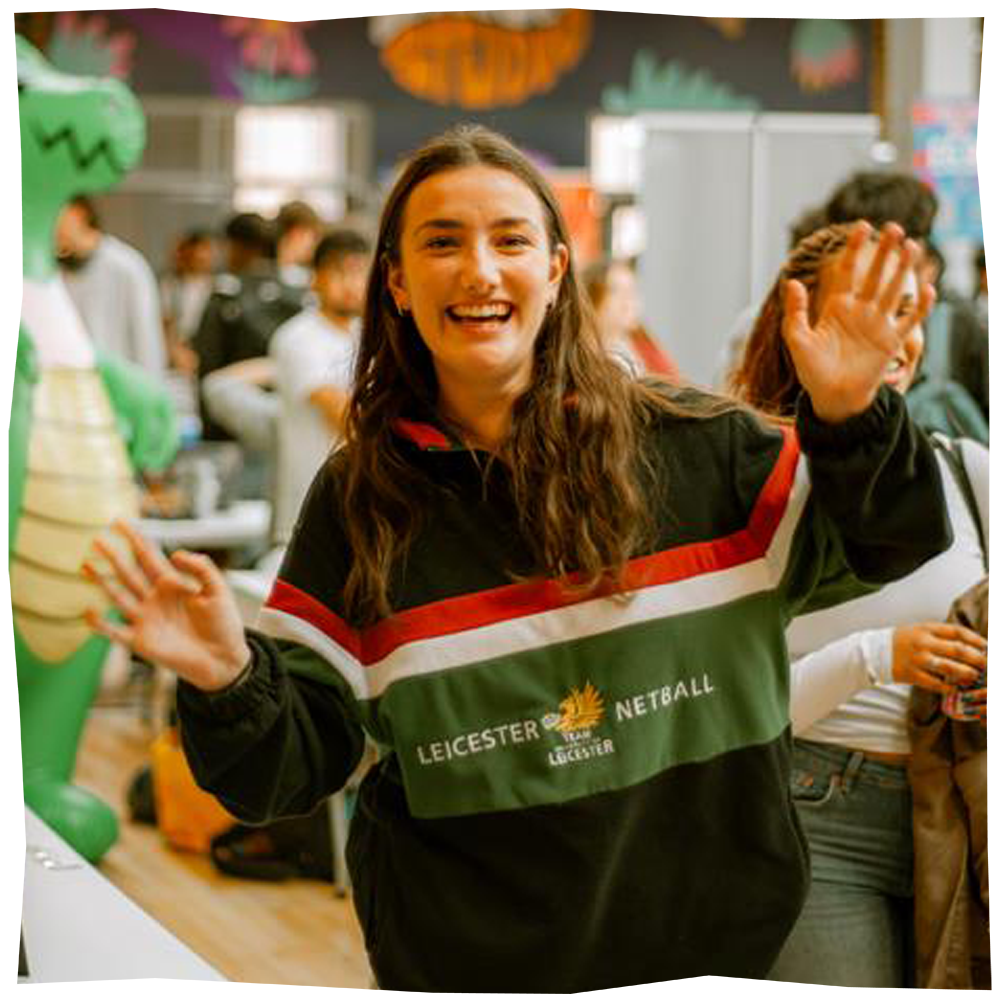 Photo of student in sports kit waving at the camera