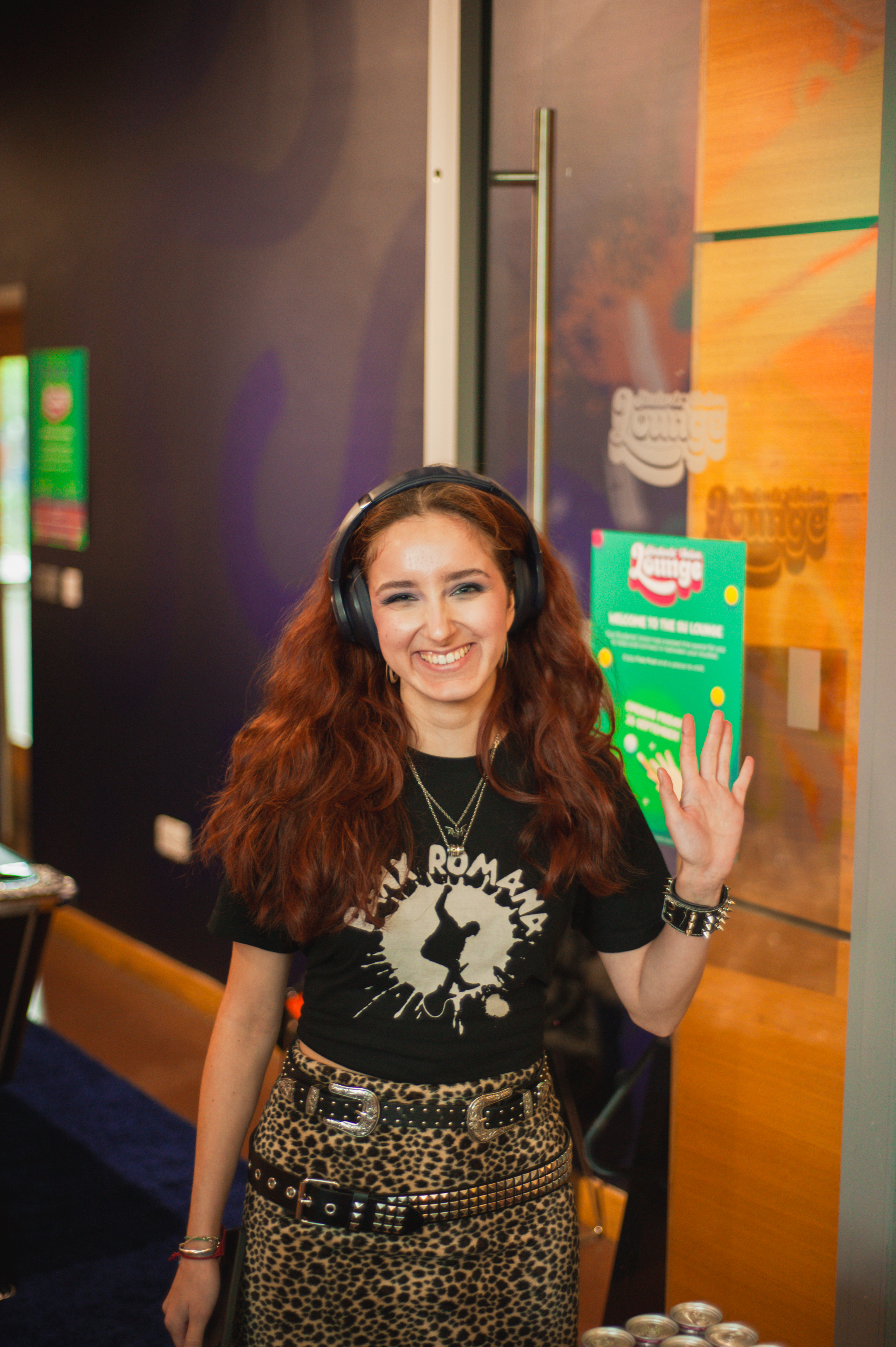 A women smiling and waving at the camera