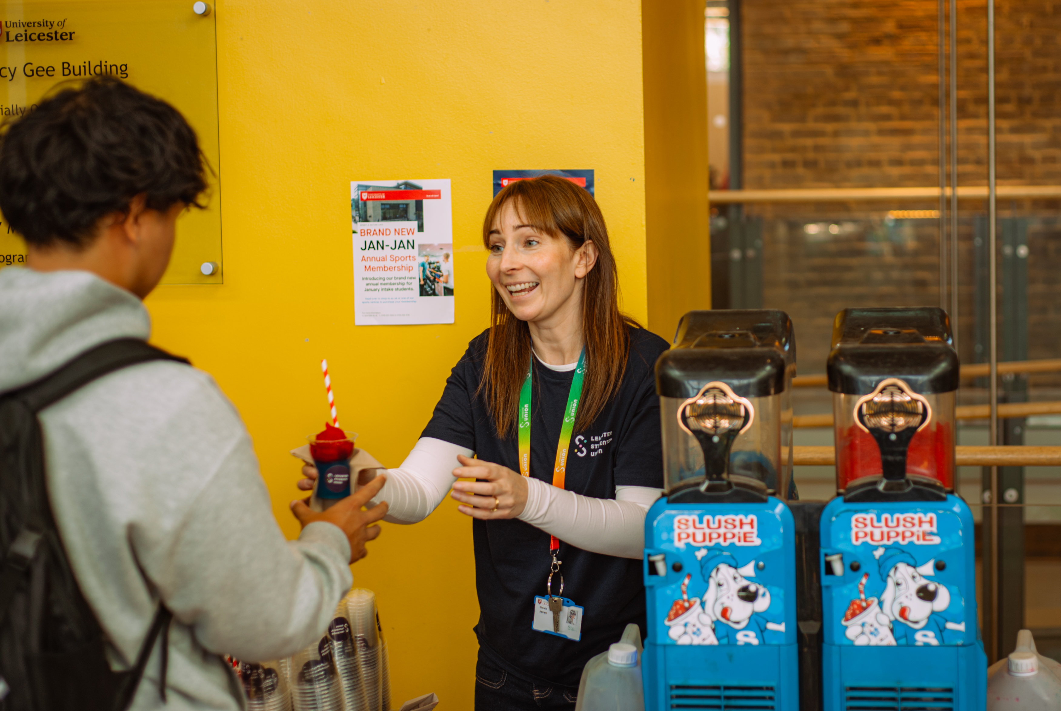 A staff member handing a slushie to a student