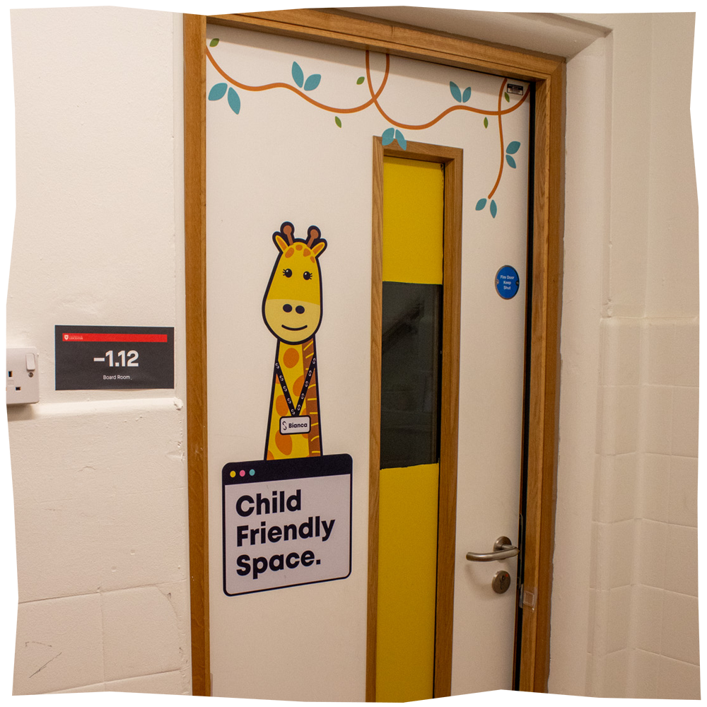 Door to Child Friendly space, featuring a giraffe illustration